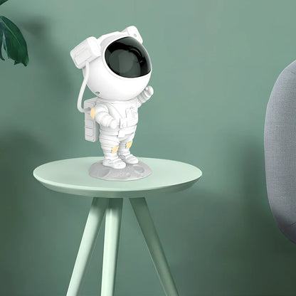 White astronaut-shaped night light projecting star patterns on ceiling with remote control