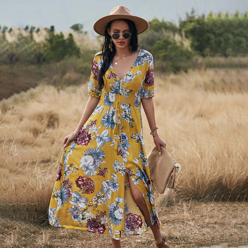 Yellow floral print women's dress with V-neck, short sleeves, elastic waist, and a large hemline midi skirt.