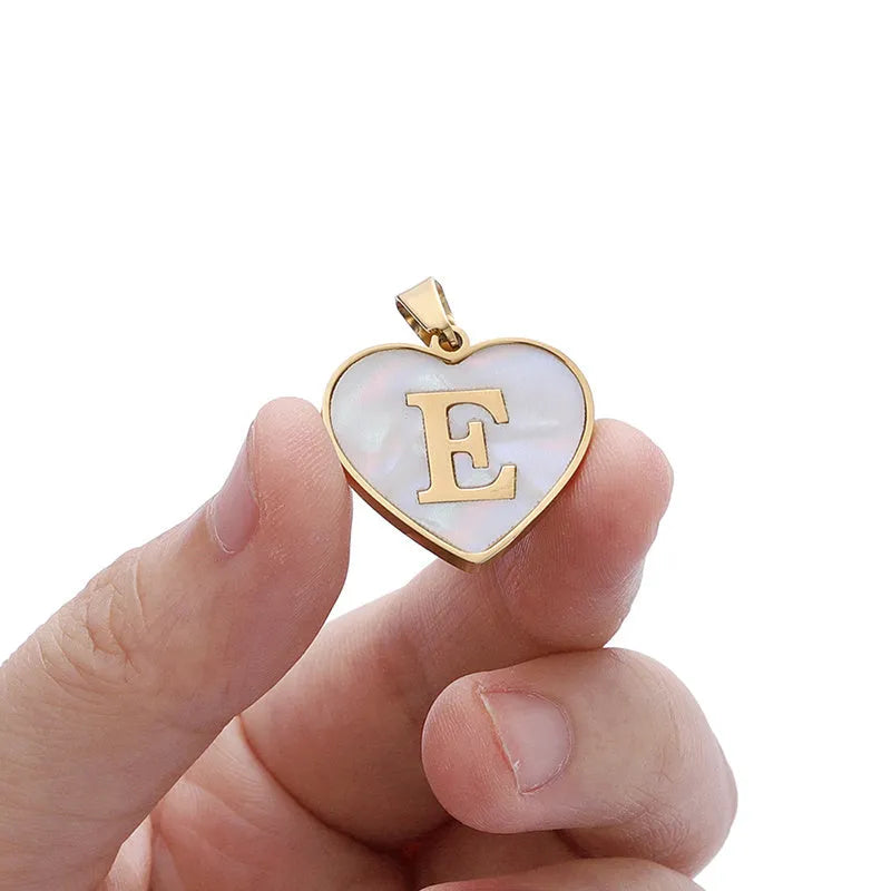 Gold-plated clavicle necklace with a white shell heart pendant, personalised with a letter from A to Z.