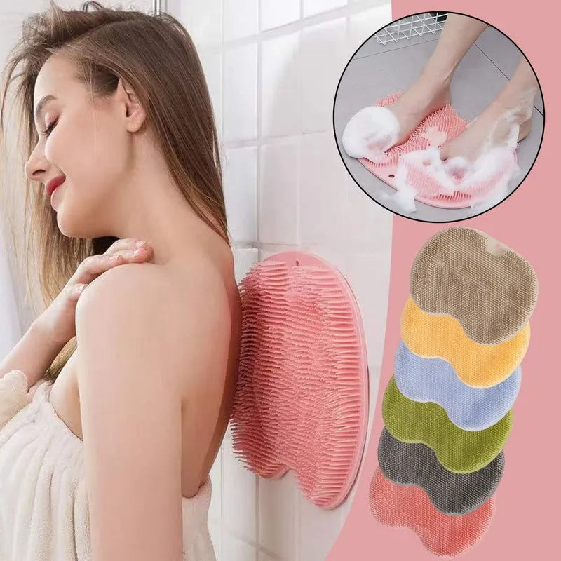 Orange non-slip massage bath brush with silicone bristles and suction cup base on shower floor