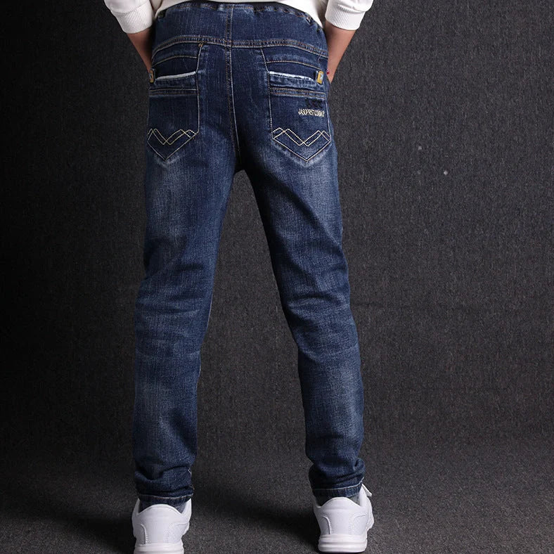 Boys' black micro-stretch cotton jeans showing 4-way flexibility and middle waist design