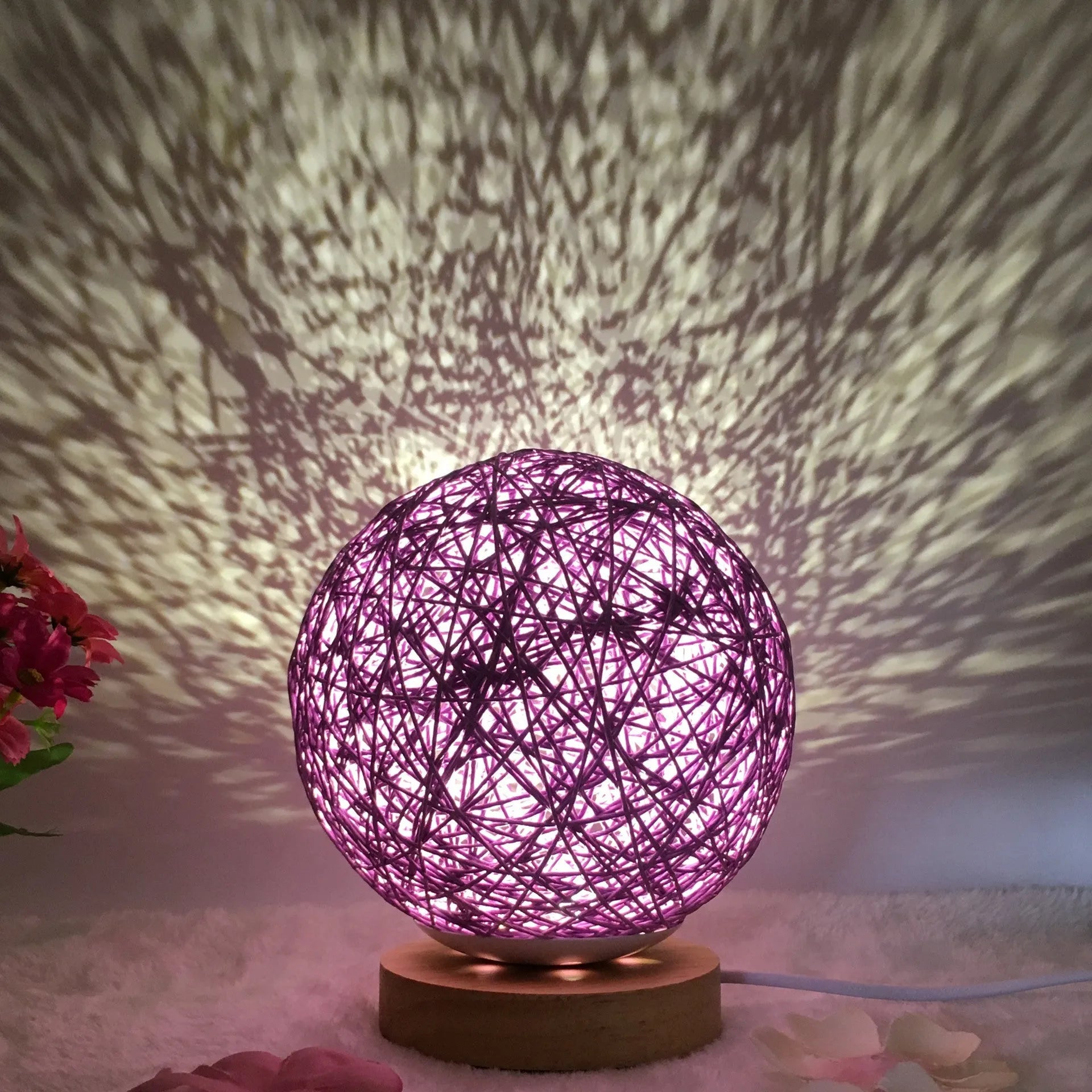 Spherical hand-knitted rattan table lamp with remote control on a wooden desk