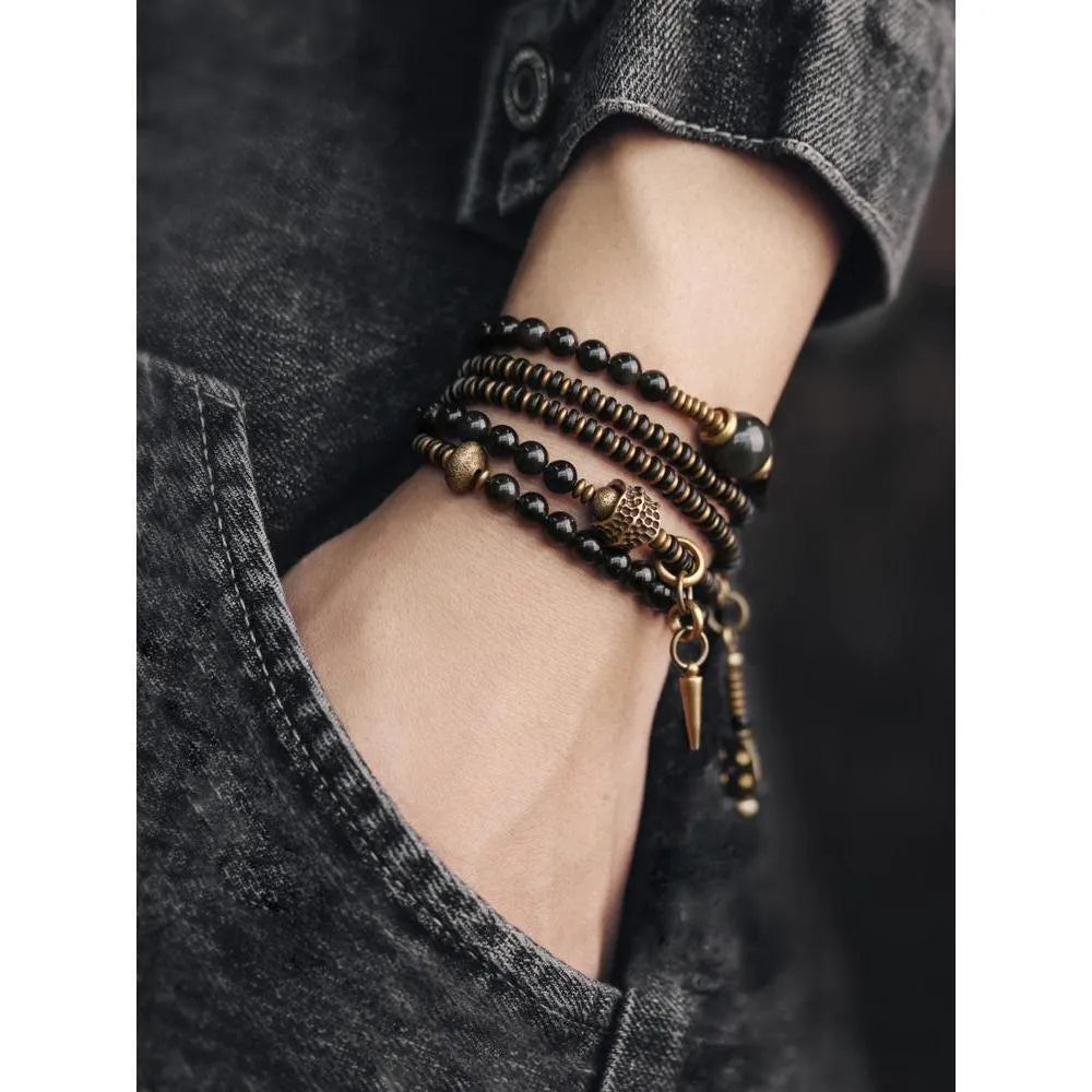 Black geometric layered beaded bracelet shown on a wrist.
