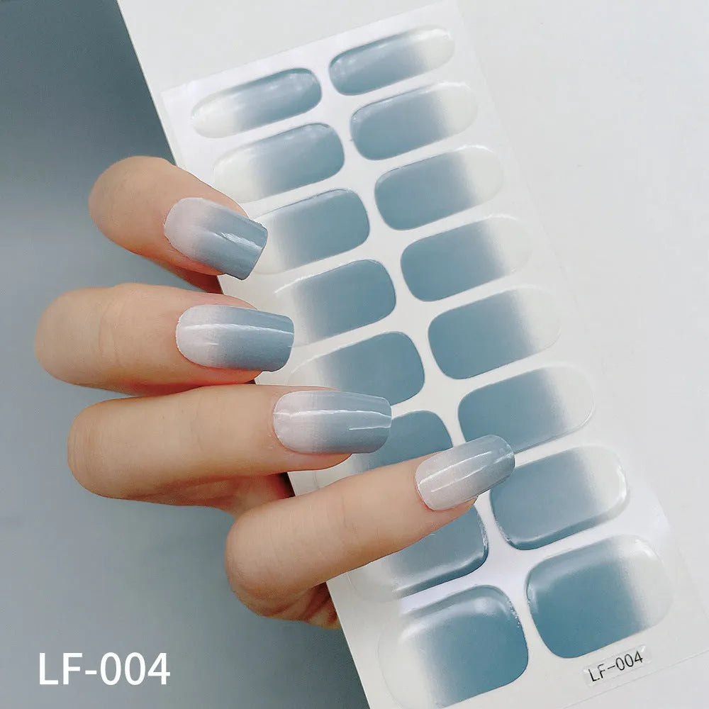 Sheet of 16 small design nail art stickers including cross, rose, tulip and marble patterns.