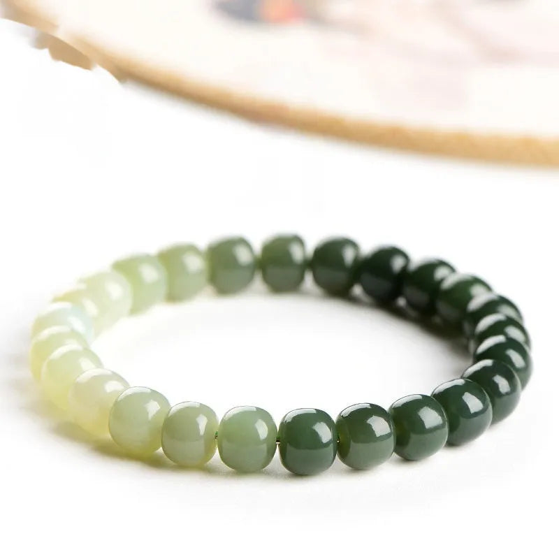 Natural Hetian jade bracelet showing gradient clear water colour on polished beads with either 6x7mm or 7x8mm dimensions
