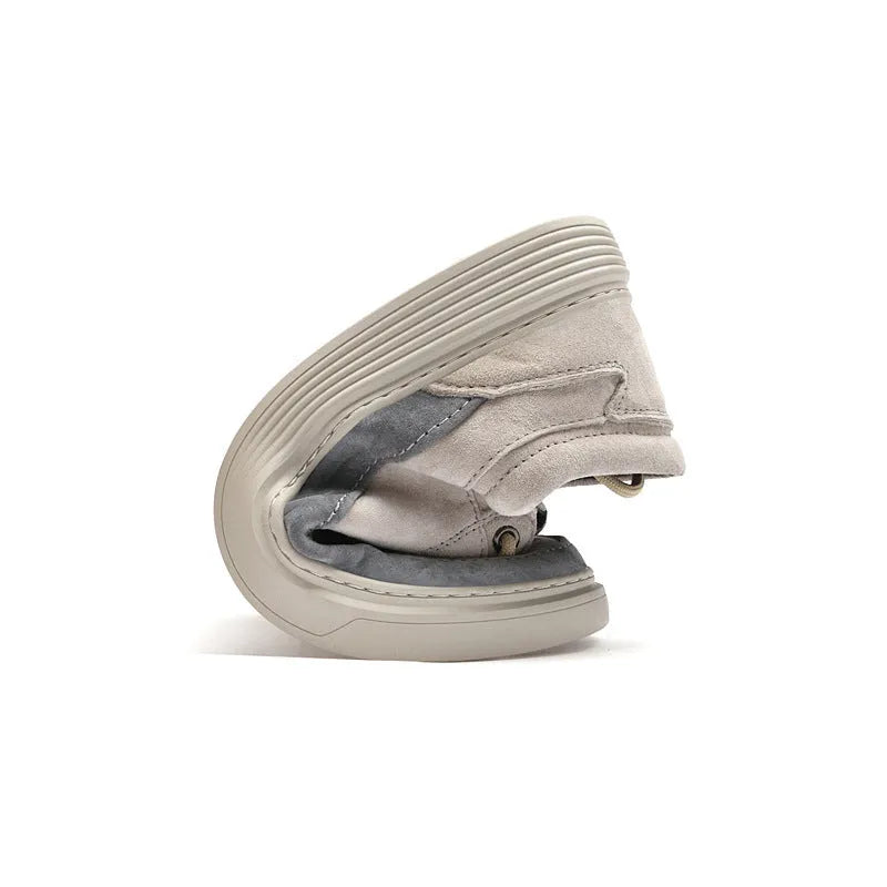 Men's grey low-top casual leather skate shoes with round toe and flat rubber sole on a wooden surface.