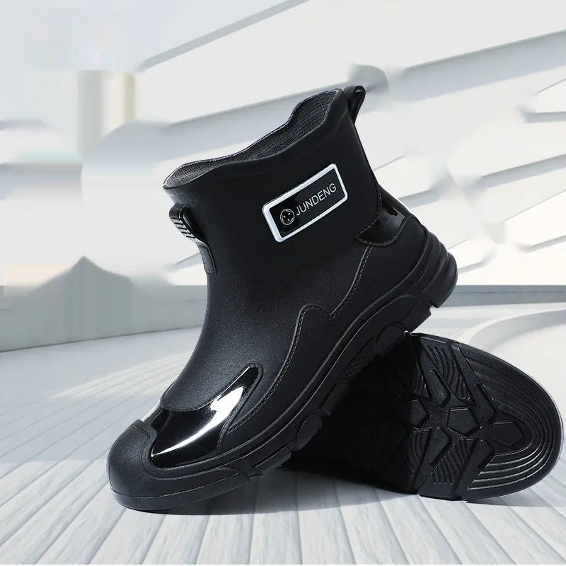 Women's short tube PVC waterproof boots in black with a round toe and flat plastic sole.