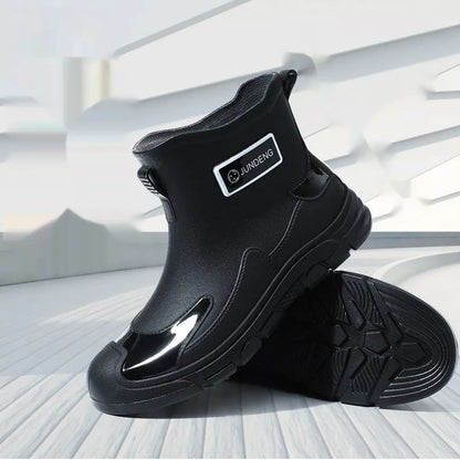 Women's short tube PVC waterproof boots in black with a round toe and flat plastic sole.