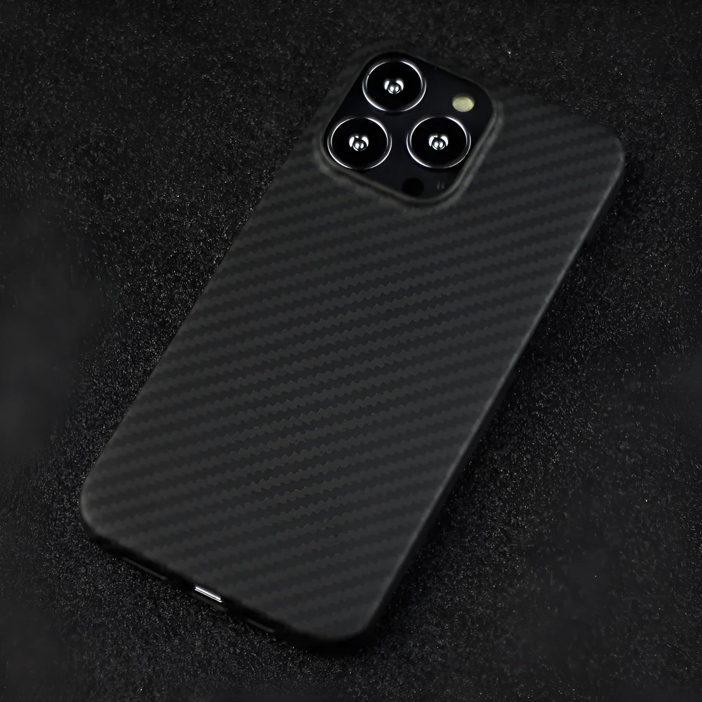 Matte black Kevlar fibre protective case for iPhone showing crater texture and exposed side buttons.
