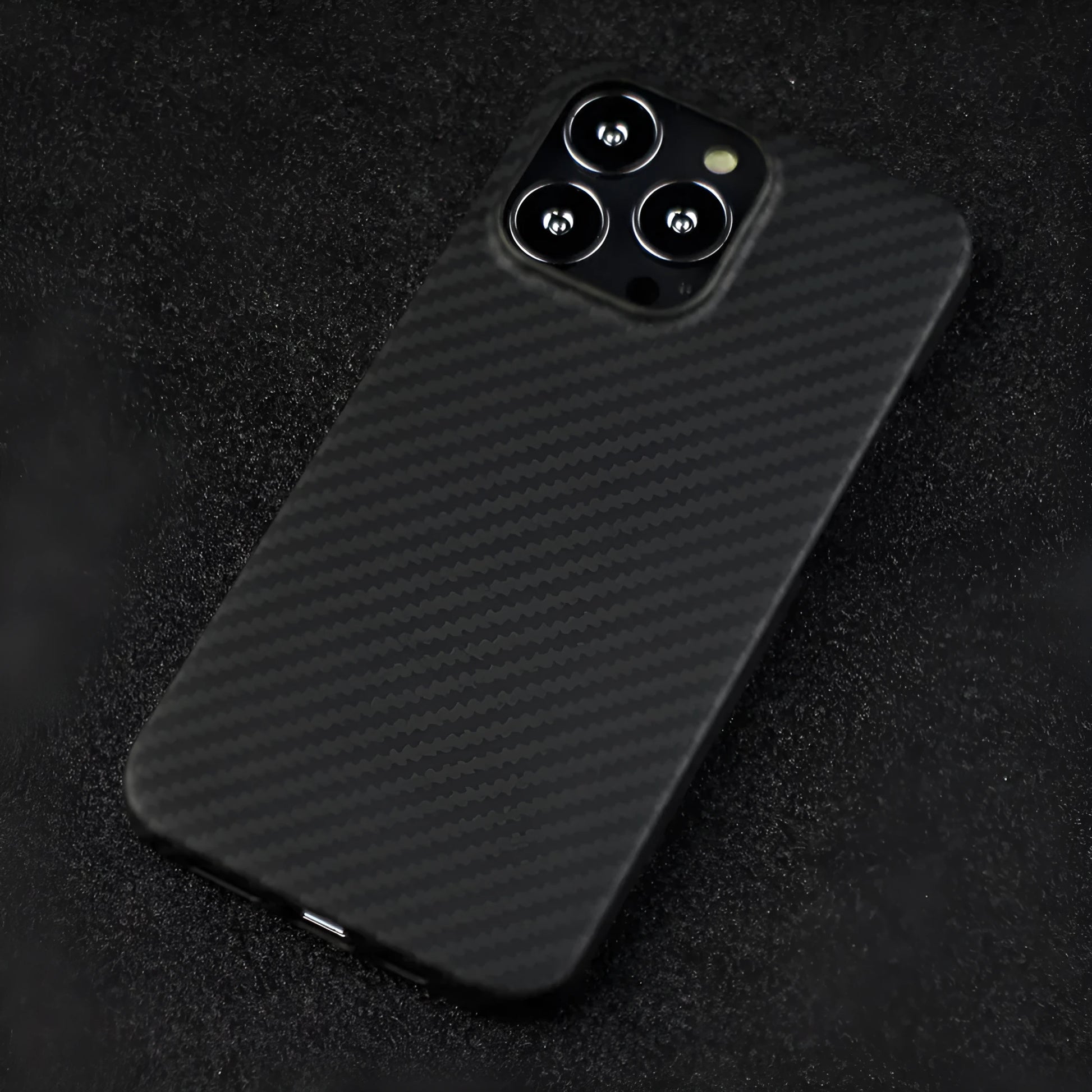 Matte black Kevlar fibre protective case for iPhone showing crater texture and exposed side buttons.