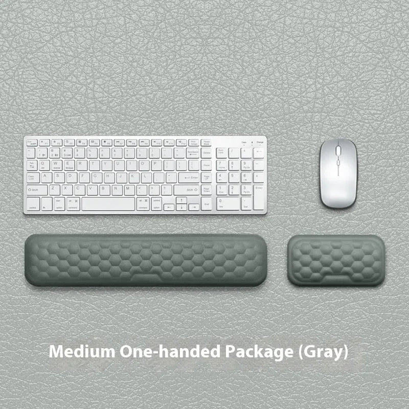 Black and grey memory foam mouse wrist rests with cloth and leather-style covers on a desk.