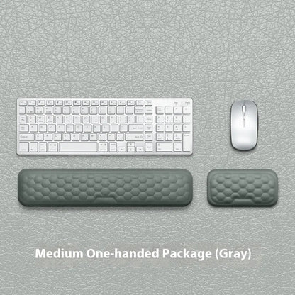 Black and grey memory foam mouse wrist rests with cloth and leather-style covers on a desk.