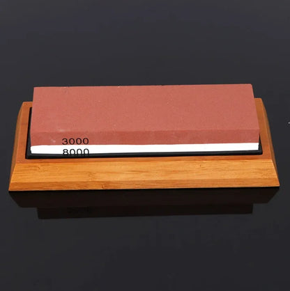 Green and white double-sided whetstone with bamboo base and sharpening accessories