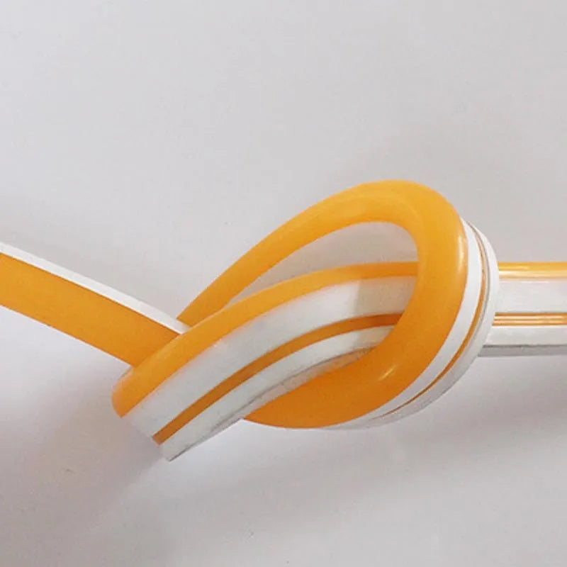 Close-up of flexible blue silicone LED neon strip showing dense LED beads, coiled on a 100-metre reel.