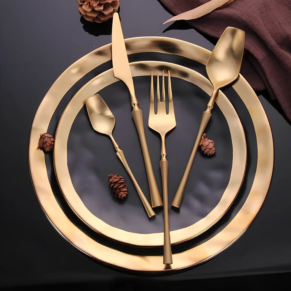 Four-piece stainless steel cutlery set showing main knife, fork, spoon, and teaspoon with mirror finish