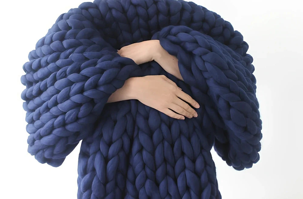 Hand woven wool blanket with soft chenille texture in navy blue colour draped over sofa