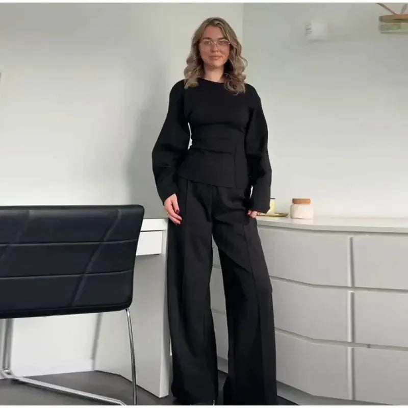 Women's black fleece tracksuit set featuring a pleated long sleeve top and wide leg trousers