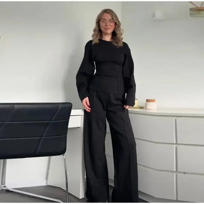 Women's black fleece tracksuit set featuring a pleated long sleeve top and wide leg trousers