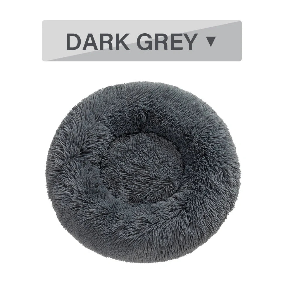 Fluffy donut-shaped dog bed in dark grey colour with raised edges, showing plush texture and circular design