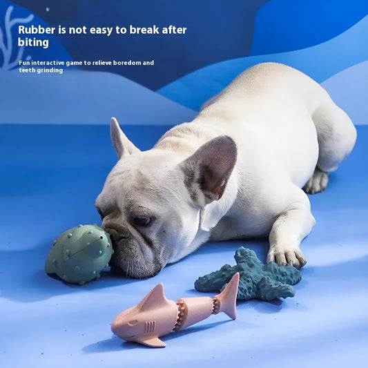 Blue rubber shark-shaped dog toy with food dispensing openings on a white background.