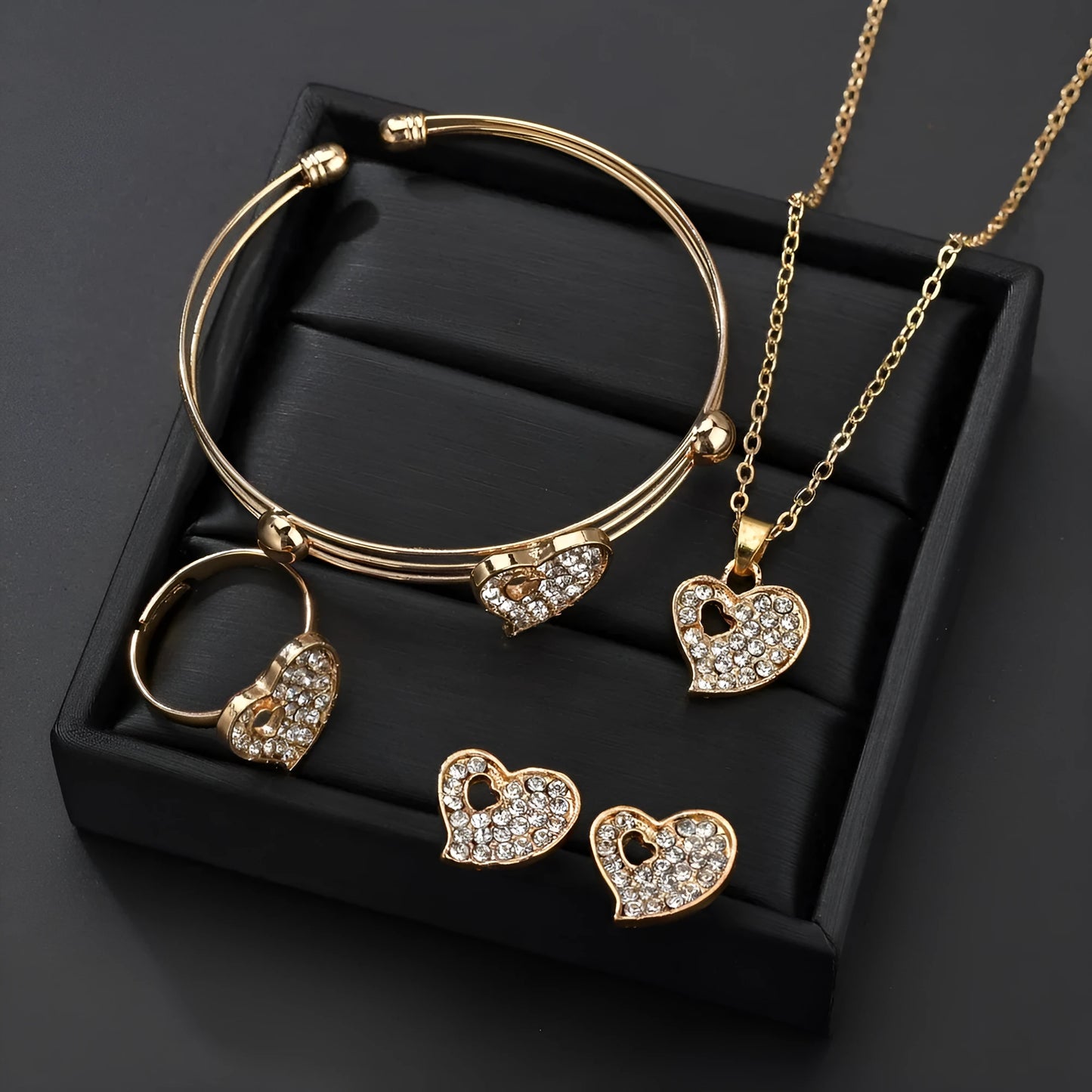 Gold-coloured women's love jewellery set with earrings, pendant and bracelet featuring bell patterns