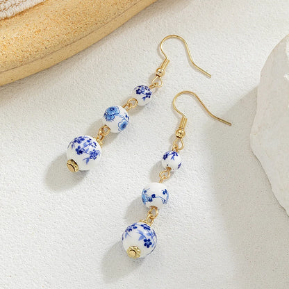 Long retro earrings with blue and white porcelain ceramic beads and geometric alloy construction