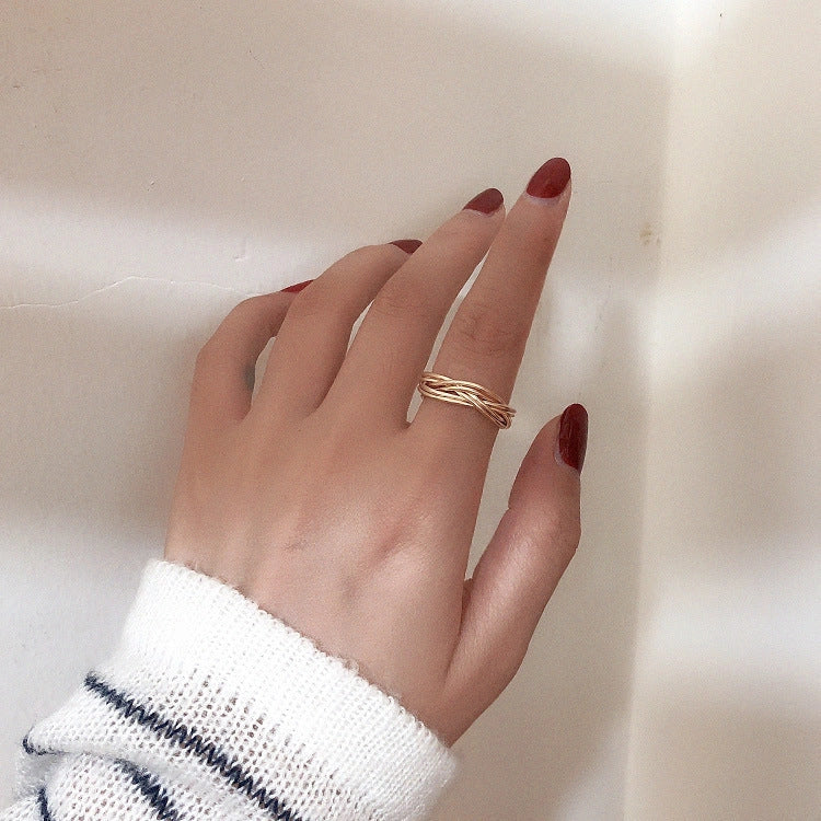 Adjustable twist metal ring in a gold tone, featuring a modern geometric design with a vintage-inspired flair.