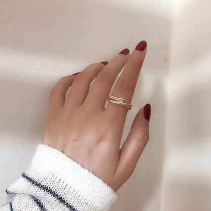 Adjustable twist metal ring in a gold tone, featuring a modern geometric design with a vintage-inspired flair.