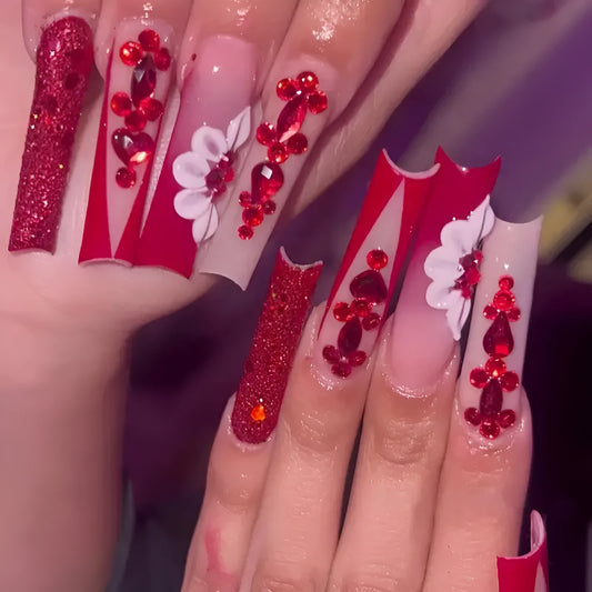 Sweet floral pattern press-on nails with red diamond accents in a long European Square shape.
