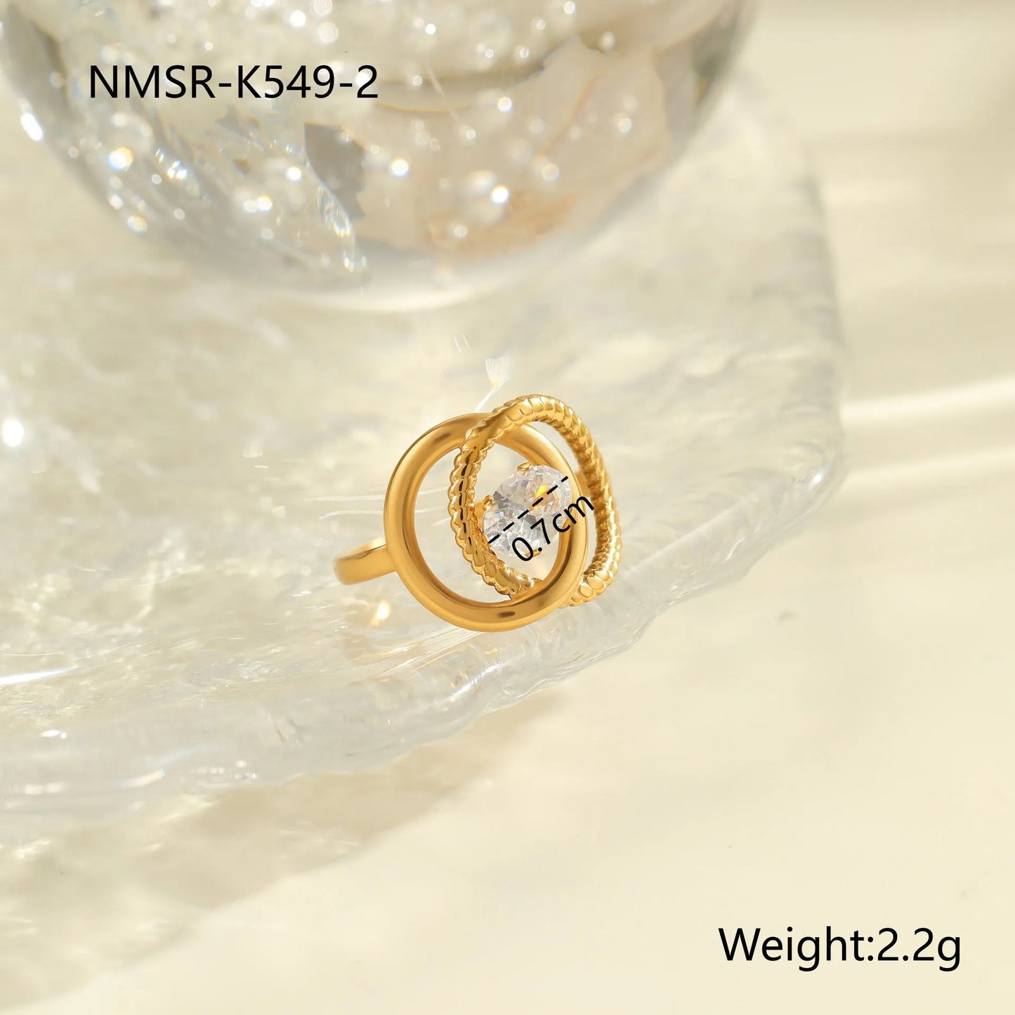 Gold electroplated stainless steel open mouth ring with geometric shapes and zircon inlay on a heart drop.