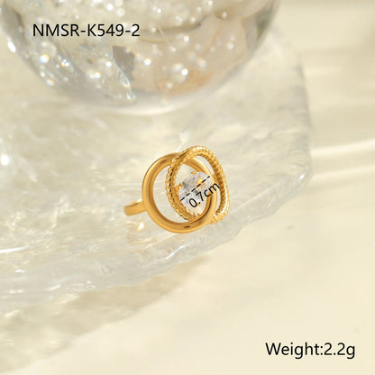 Gold electroplated stainless steel open mouth ring with geometric shapes and zircon inlay on a heart drop.