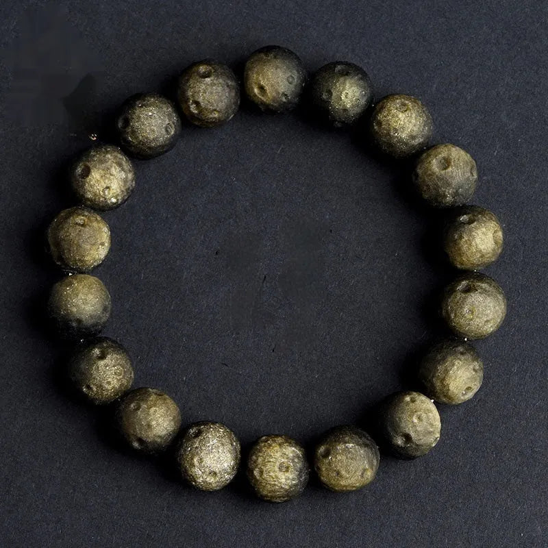 Natural obsidian crater ball bracelet with grinding treatment showing smooth bead texture in silver or golden meteorite colours