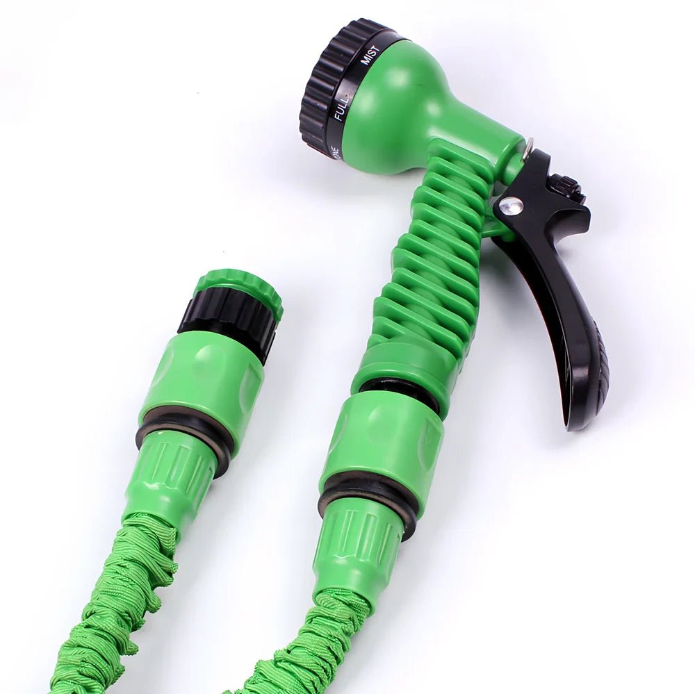 Expandable flexible water hose with spray gun showing green colour and extended length with water spraying in cone pattern