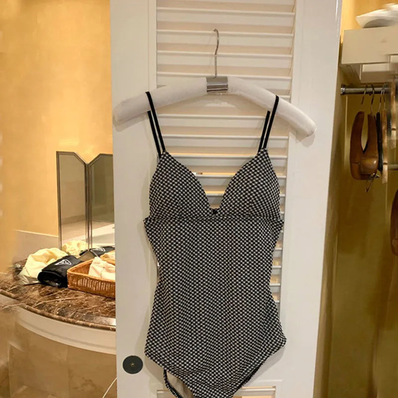 Black or blue one-piece swimsuit with a belt covering the belly, designed for a smaller chest.