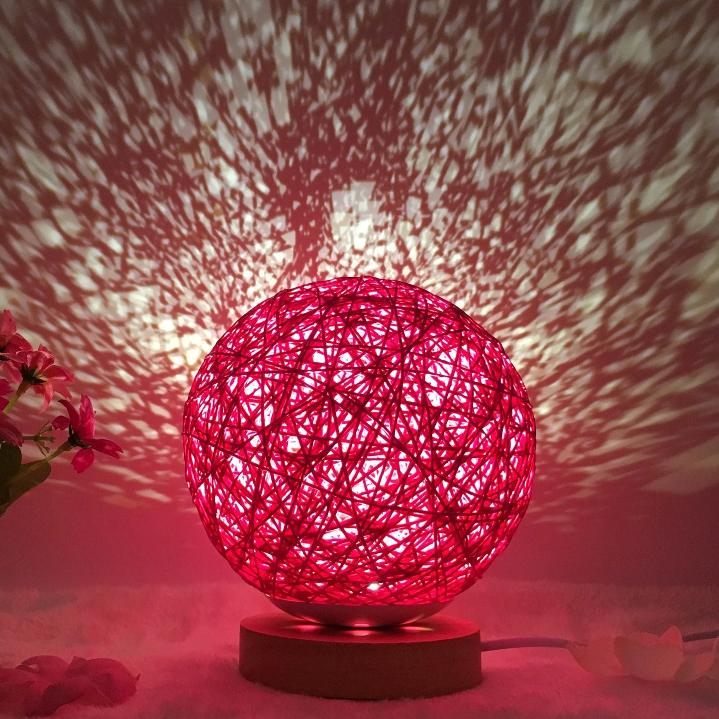 Spherical hand-knitted rattan table lamp with remote control on a wooden desk