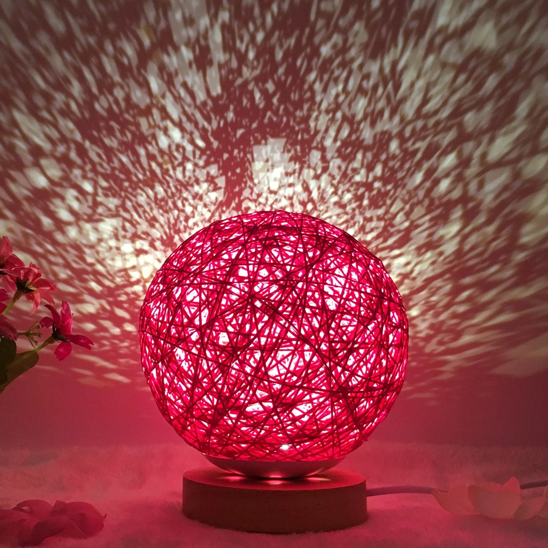 Spherical hand-knitted rattan table lamp with remote control on a wooden desk