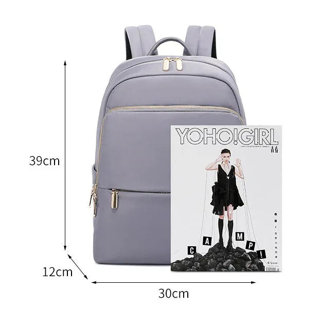 Oxford cloth women's backpack in black or purplish grey showing large capacity and padded straps