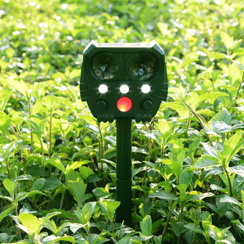 Green solar-powered ultrasonic dog and pest repeller unit for outdoor garden protection