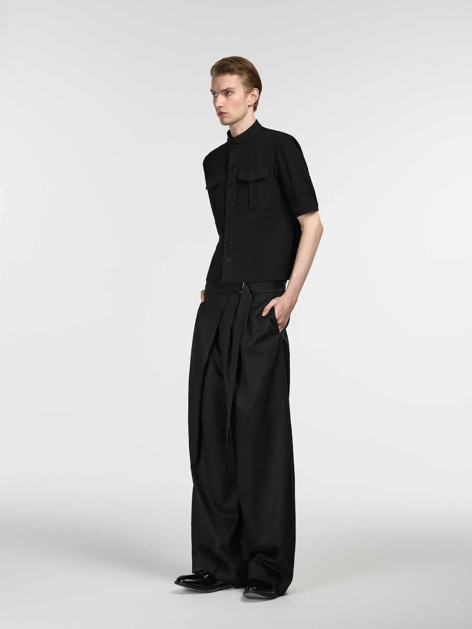 Black straight-leg trousers with a single front pleat and adjustable waistband, made from Tencel and cotton.