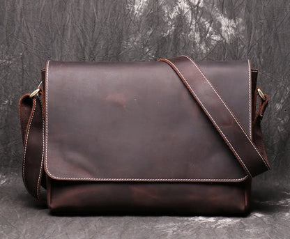 Vintage brown leather mens messenger bag with flap open, showing internal phone pouch and zipper pocket.