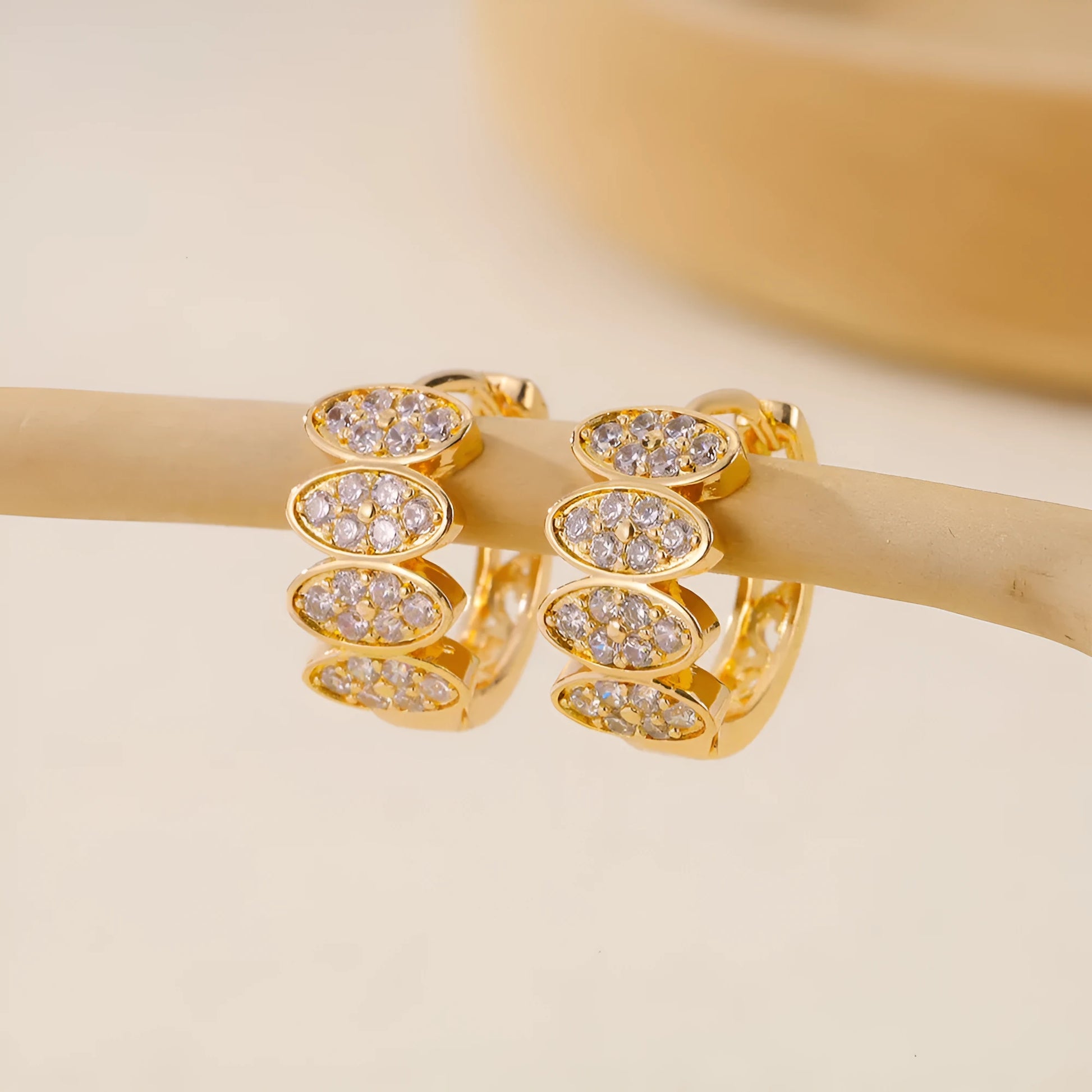 Women's gold colour ear rings with zircon stone mosaic detailing on copper construction