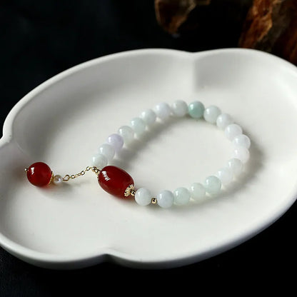 Women's ethnic bracelet with hanging red agate tassel and 14K gilded geometric design