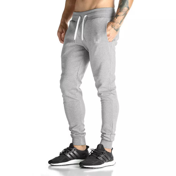 Running training pants in black, light gray, or dark gray with 95% cotton fabric and cord closure