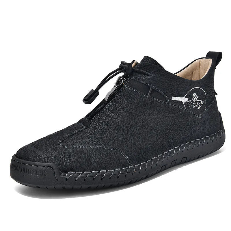 Men's black casual leather shoes with a mid heel, round toe, and visible stitching on a wooden floor.
