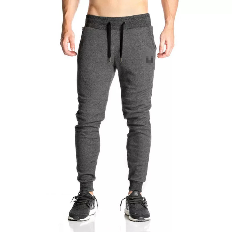 Running training pants in black, light gray, or dark gray with 95% cotton fabric and cord closure