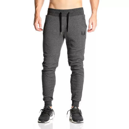 Running training pants in black, light gray, or dark gray with 95% cotton fabric and cord closure