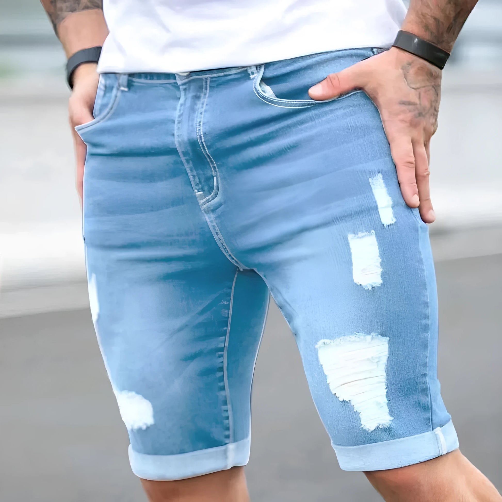 Men's sky blue denim shorts with multi-hole distressed design and a zip fly.