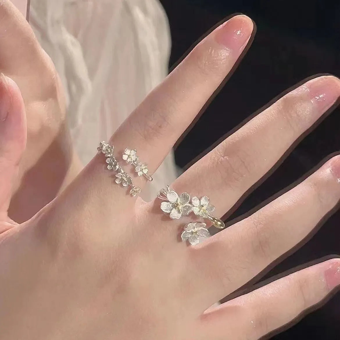 Adjustable open-mouth ring with a detailed three-dimensional jasmine flower design in a metallic finish.
