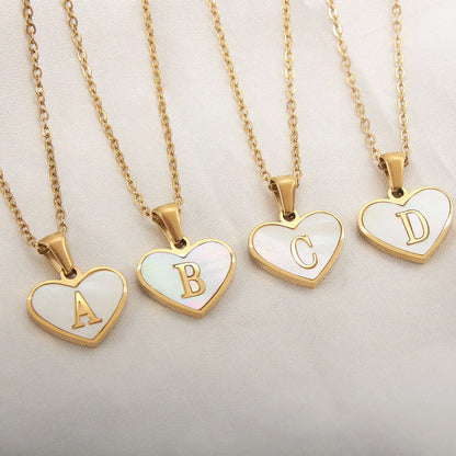 Gold-plated clavicle necklace with a white shell heart pendant, personalised with a letter from A to Z.