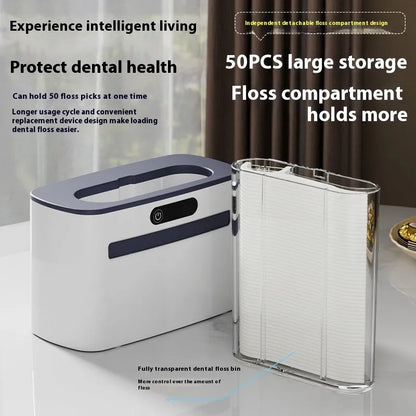 Dark grey automatic electric dental floss box with pop-up mechanism on a bathroom counter.